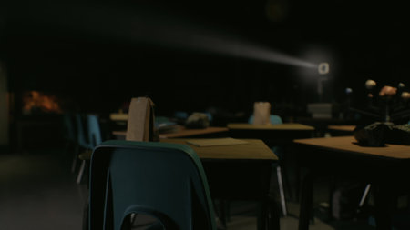 In a dimly lit classroom, empty desks stand ready for students. A projector casts light on the wall,...