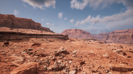 Expansive red rocks stretch endlessly under a blue sky, revealing dramatic formations. The sun casts shadows on the rugged terrain, creating a vivid desert scene filled with natural beauty.の写真素材