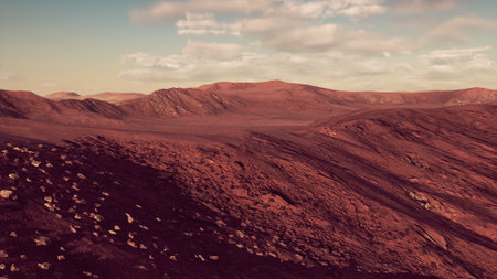 Expansive red hills stretch across the horizon, dusted with scattered stones, under a sky filled with soft, fluffy clouds. The landscape evokes a sense of adventure and discovery.の写真素材