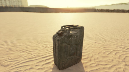 In a vast desert at sunset, an old metal canister stands alone on the warm sand, casting long shadows as the golden light bathes the landscape in a tranquil glow.の写真素材