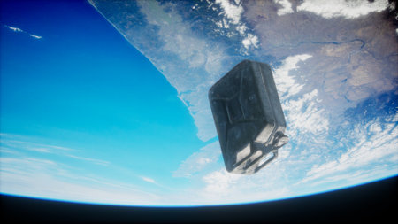 A dark container drifts in space, captured from a high vantage point above Earth. The stunning blue of the planet contrasts against the vast blackness of the universe, evoking awe.の写真素材