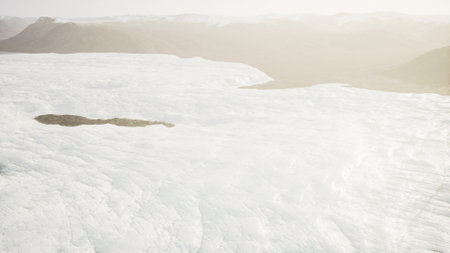Cold ice stretches across the terrain, with the warm glow of the early morning sun casting a gentle...
