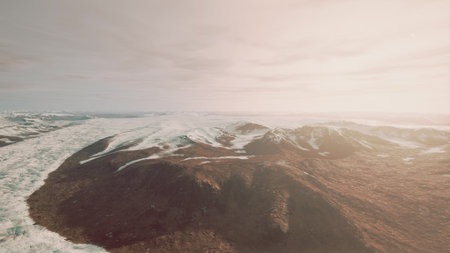 Snow covered mountains meet rocky terrain under a soft sunrise. The icy expanse showcases natures beauty as light reflects off the glaciers, creating a serene atmosphere.の写真素材