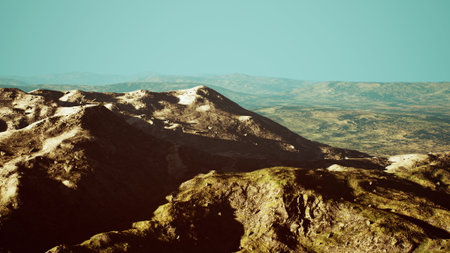 Breathtaking mountains stretch across the horizon under a clear blue sky. Sunlight highlights the rugged terrain and vibrant colors of the landscape, inviting exploration and adventure.の写真素材