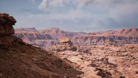 Stunning vistas of rust colored rock formations extend across a barren desert landscape, framed by a swirling blue and gray sky.の写真素材