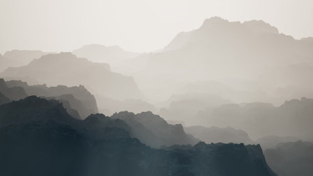 Layers of mountains rise and fall softly in the distance, enveloped in a gentle mist. The early morning light casts a serene glow, creating a tranquil and ethereal atmosphere.の写真素材