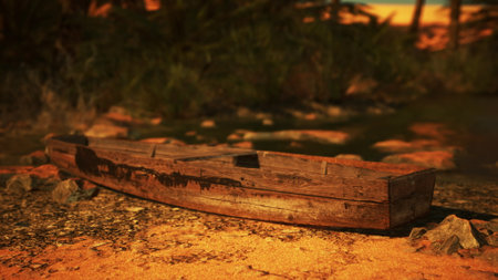 A weathered wooden boat lies on the sandy shore, surrounded by rocks and vegetation. The sun sets in the background, casting warm golden hues over the landscape, creating a serene atmosphere.の写真素材