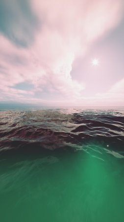 Gentle waves ripple under a bright, colorful sky, reflecting the sunlight. The tranquil ocean stretches endlessly, blending shades of blue and green for a serene scene.の写真素材