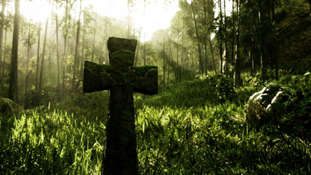 A weathered cross stands tall in the midst of vibrant green grass and towering trees, illuminated by soft sunlight filtering through the leaves. Nature thrives around this serene spot.の写真素材
