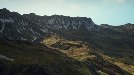 A breathtaking view of rugged mountains bathed in morning light. Peaks show snow while lush green valleys shimmer. Nature awakens as a tranquil scene unfolds with the sun rising.の写真素材