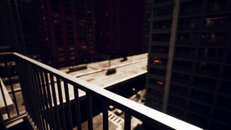 A stunning view from a balcony overlooking a bustling city at night. Bright lights illuminate the buildings, creating a vibrant atmosphere as traffic moves below on the streets.の写真素材