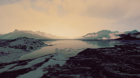 Colors blend gently in the sky as the sun sets behind distant peaks. The calm lake reflects the soft...