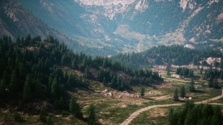 A scenic view of a mountain valley with a road winding through itの写真素材