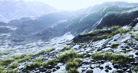 A rugged mountainside showcases patches of green grass amidst rocky terrain, illuminated by bright sunlight. The atmosphere feels serene, inviting exploration of the natural beauty.の写真素材