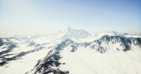Majestic peaks rise above a vast expanse of untouched snow, illuminated by a bright blue sky. The tranquil setting evokes a sense of peace and natural beauty in winter.の写真素材