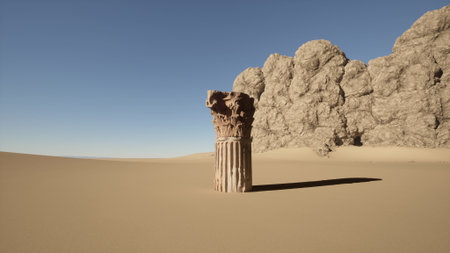 A weathered column rises from the golden sands, surrounded by a vast desert. Towering rock formations loom nearby, casting long shadows in the afternoon light, evoking a sense of time and history.の写真素材