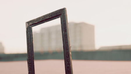 A unique frame stands alone against a hazy background, offering a creative glimpse of the city during sunset. The warm light bathes the scene, adding depth and beauty.の写真素材