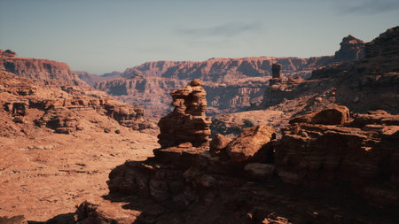 A rugged terrain dominated by scattered rocks with a towering mountain in the background under a clear sky.の写真素材