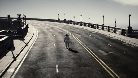 An astronaut in a white space suit strolls down a lonely, winding road. Street lamps line the pathway, casting shadows as the hazy sky looms overhead, creating a surreal atmosphere.の写真素材