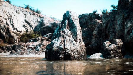 In a peaceful landscape, a majestic rock formation stands tall amidst calm waters. Clear skies above and rugged terrain enhance the beauty of this natural haven.の写真素材