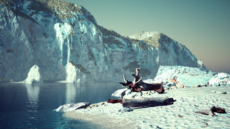 Beautiful landscape showcases a tranquil beach at sunset, featuring rocky cliffs in the background and gentle waves lapping at the shore. Driftwood adds a natural touch to the scene.の写真素材