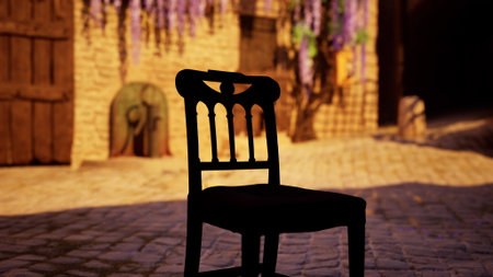 In a quiet village at sunset, a lone chair sits on a cobblestone street. Vibrant purple flowers hang nearby, adding color to the warm, golden light that envelops the scene.の写真素材