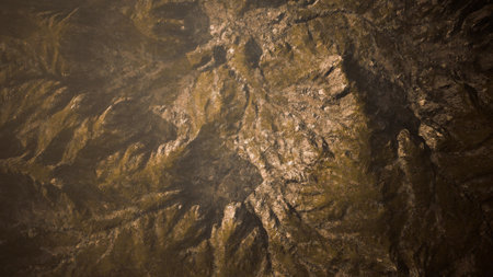 The rugged terrain showcases an array of peaks and valleys, illuminated by the warm glow of the setting sun. Shadows dance across the surface, creating a captivating display of natures artistry.の写真素材