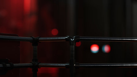 In a dimly lit urban environment, a metallic structure is highlighted by a captivating red glow....