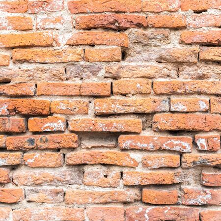 Cracked ruin and dirty orange brick wall backgroundの写真素材