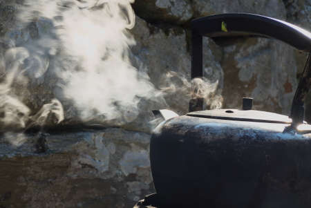 an iron kettle that boils and steams outの写真素材