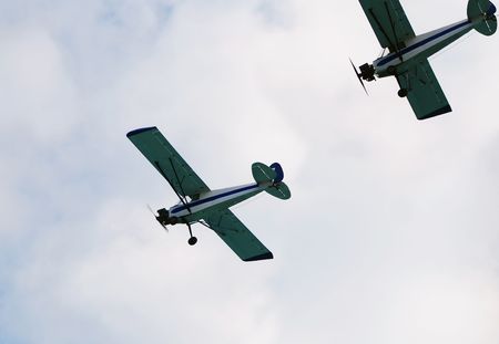 Two vintage propeller airplanes in formation               