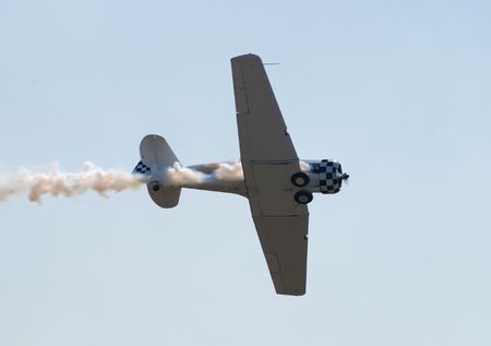 Vintage propeller airplane with smoke trail