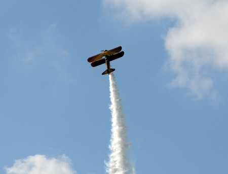Old fashioned biplane soaring into the clouds
