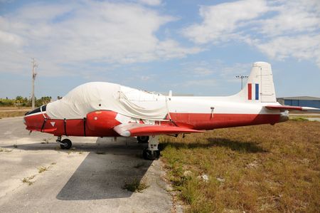 Old military jet airplane abandoned on a field