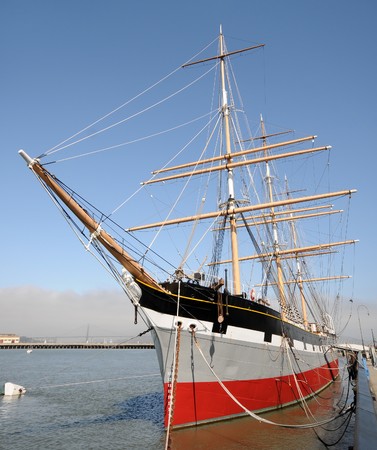 Old tall ship tied down in port