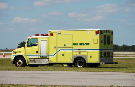 Yellow colored fire rescue truck parked ina field