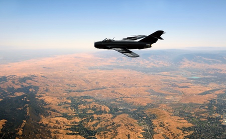 Black colored jetfighter flying high over countrysideのeditorial素材