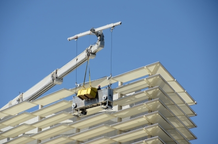 Workers clean and maintain exterior of highrise building
