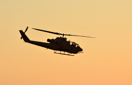 Vietnam War era army helicopter flying at sunset side view