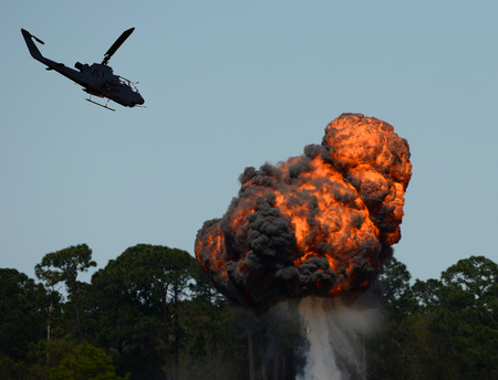 Military helicopter flying over fiery explosion and fireballのeditorial素材