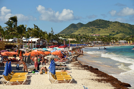 ORIENT BEACH - DECEMBER 24: Tourists enjoy a sunny day on world famous Orient Beach, Saint Maarten on December 24, 2014のeditorial素材