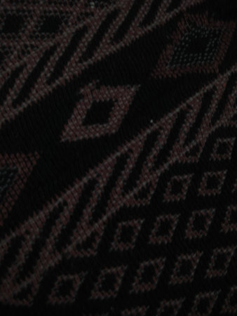The texture of the fabric is black with a pattern of geometric shapes.