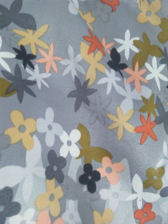 Texture, background, pattern. Silk fabric is decorated with flowers. Flower pattern on the fabric.