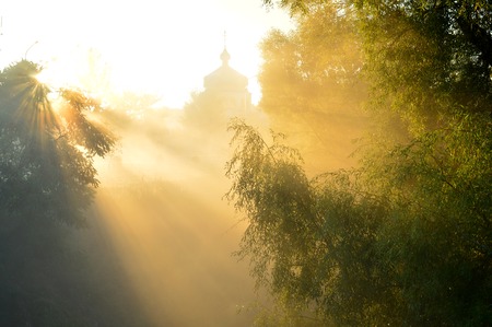 misty morning and sun's rays on the temple. Ukraineの写真素材