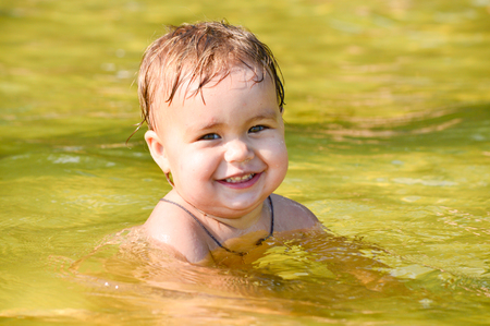 girl bathes in the lake water with a green tintの写真素材