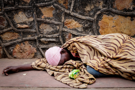 RAJGIR, INDIA - DECEMBER 4, 2016: An old man sleeps and beg tourists for money or food on the way...