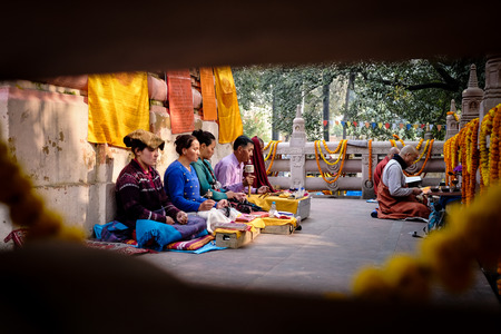 GAYA, INDIA - DECEMBER 3, 2016: Buddhist men and women pray and meditate at Bodh Gaya Stupa, Gaya, India.のeditorial素材