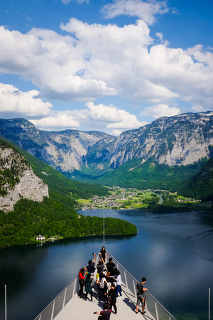 HALLSTATT, AUSTRIA - MAY 18, 2017: Tourists enjoy taking photos of the spectacular aerial view of the lakeside villages and mountain range at the World Heritage Viewing Platform in Hallstatt, Austria.のeditorial素材