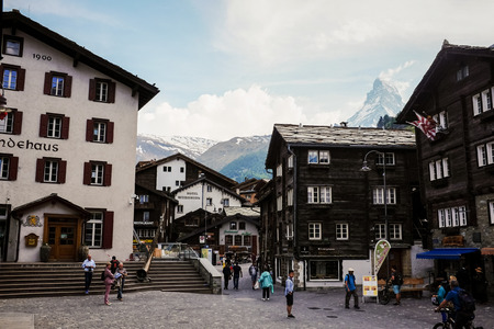 ZERMATT, SWITZERLAND - MAY 30, 2017: Tourists wander around the center of village with Matterhorn Peak at the background in Zermatt, Switzerland.のeditorial素材
