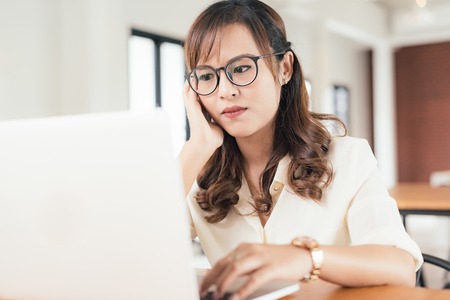 Asian young business freelance woman concentrate working online business with laptop and cell phone in cafe shop. Working, Success, concentrate concept.の写真素材